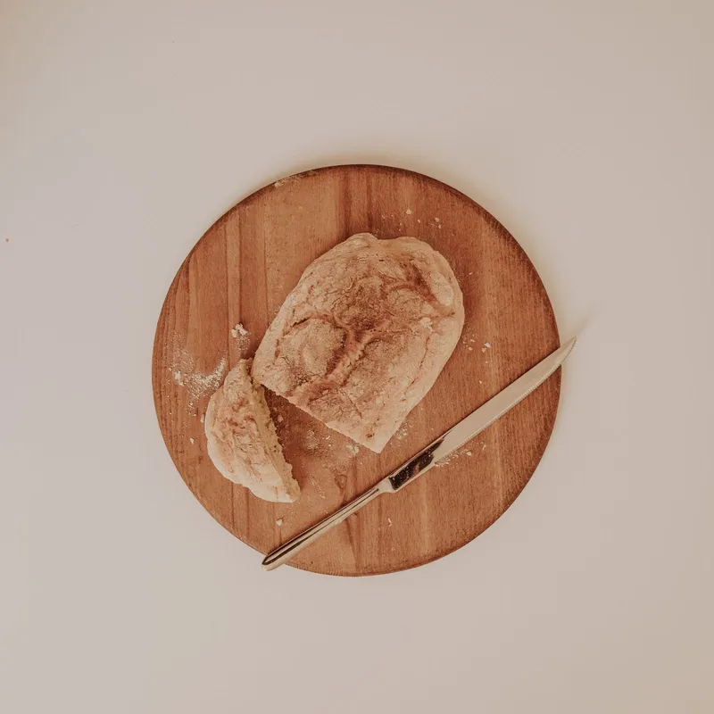 Miches et pains de campagne rangés sur une étagère du fournil