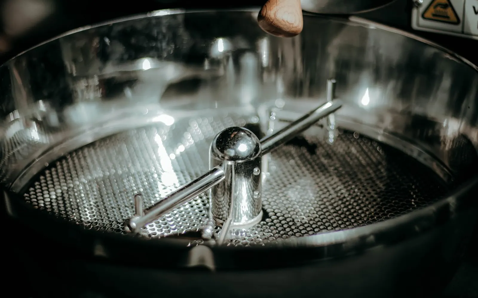 Vue plongeante dans le bac de refroidissement d’un torréfacteur, bras brasseurs en inox